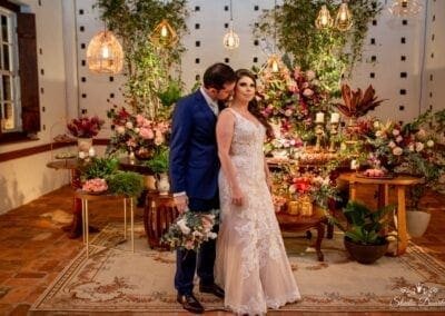 Noivos em frente à mesa decorada com flores