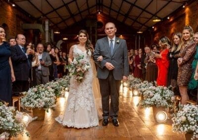 Noiva caminhando até o altar entre flores