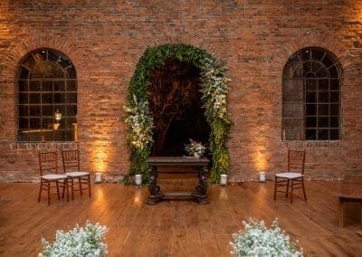 Altar com arco ao fundo decorado com flores brancas